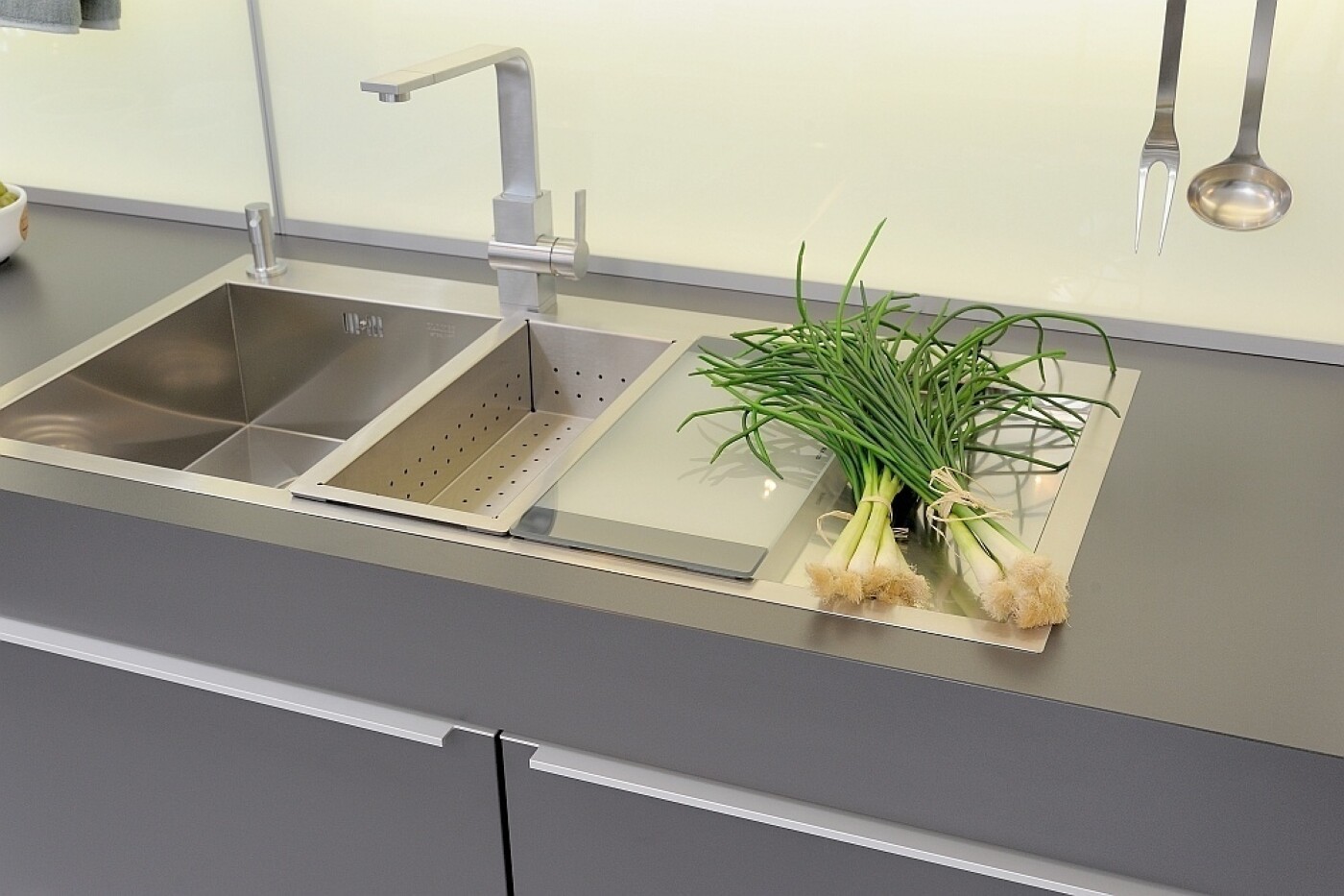 Küchenspüle aus hochwertigem Edelstahl, ergänzt durch genau passendes Schneidebrett und Abtropfbehälter Küchenspüle aus hochwertigem Edelstahl, ergänzt durch genau passendes Schneidebrett und Abtropfbehälter