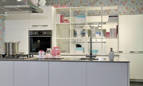 Die freistehende Theke, grifflos und matt lackiert, schafft eine ruhige Barriere zum Küchenbereich. Die freistehende Theke, grifflos und matt lackiert, schafft eine ruhige Barriere zum Küchenbereich.